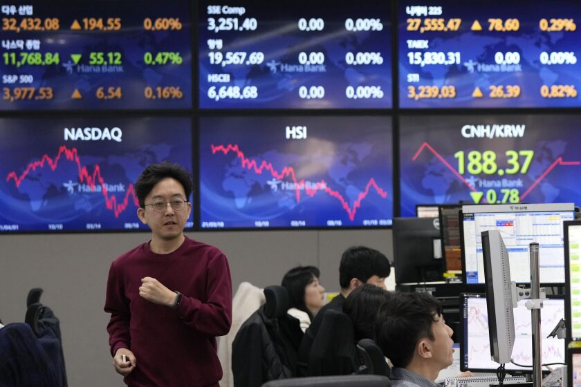 A currency trader passes by the screens showing the foreign exchange rates at the foreign exchange dealing room of the KEB Hana Bank headquarters in Seoul, South Korea, Tuesday, March 28, 2023. Asian shares were mostly higher on Tuesday as investors got some relief from worries over troubled U.S. banks with a planned takeover of failed Silicon Valley Bank.(AP Photo/Ahn Young-joon)