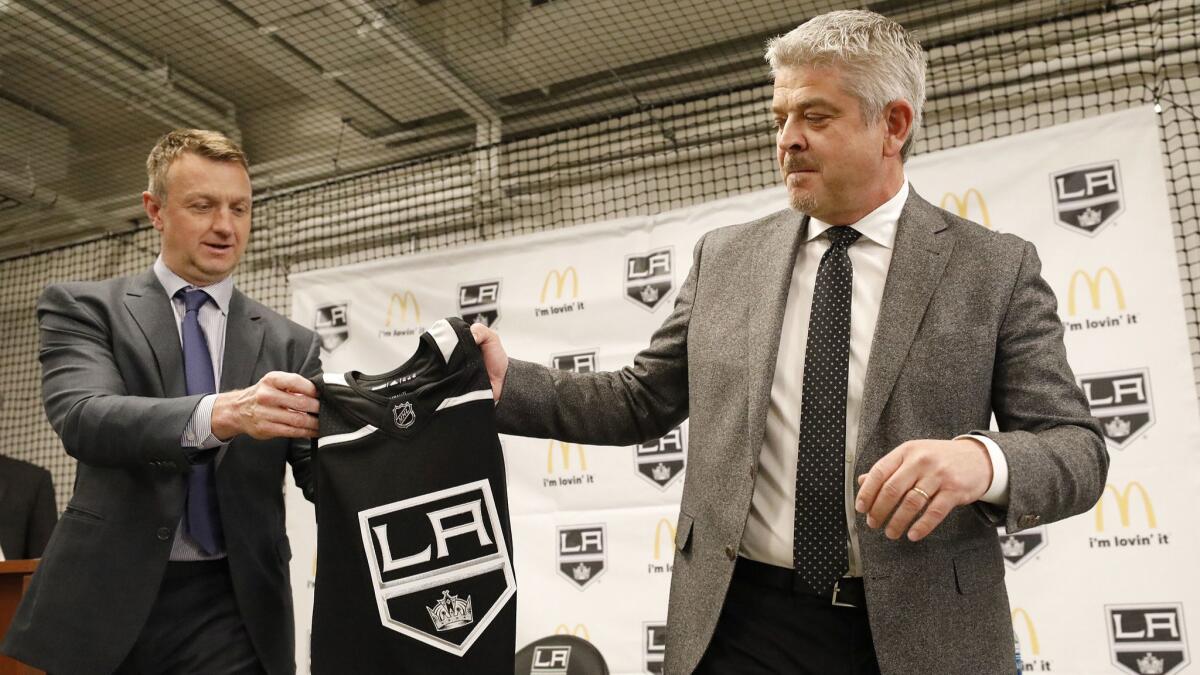 Kings general manager Rob Blake, left, presents a personalized team jersey to Todd McLellan.