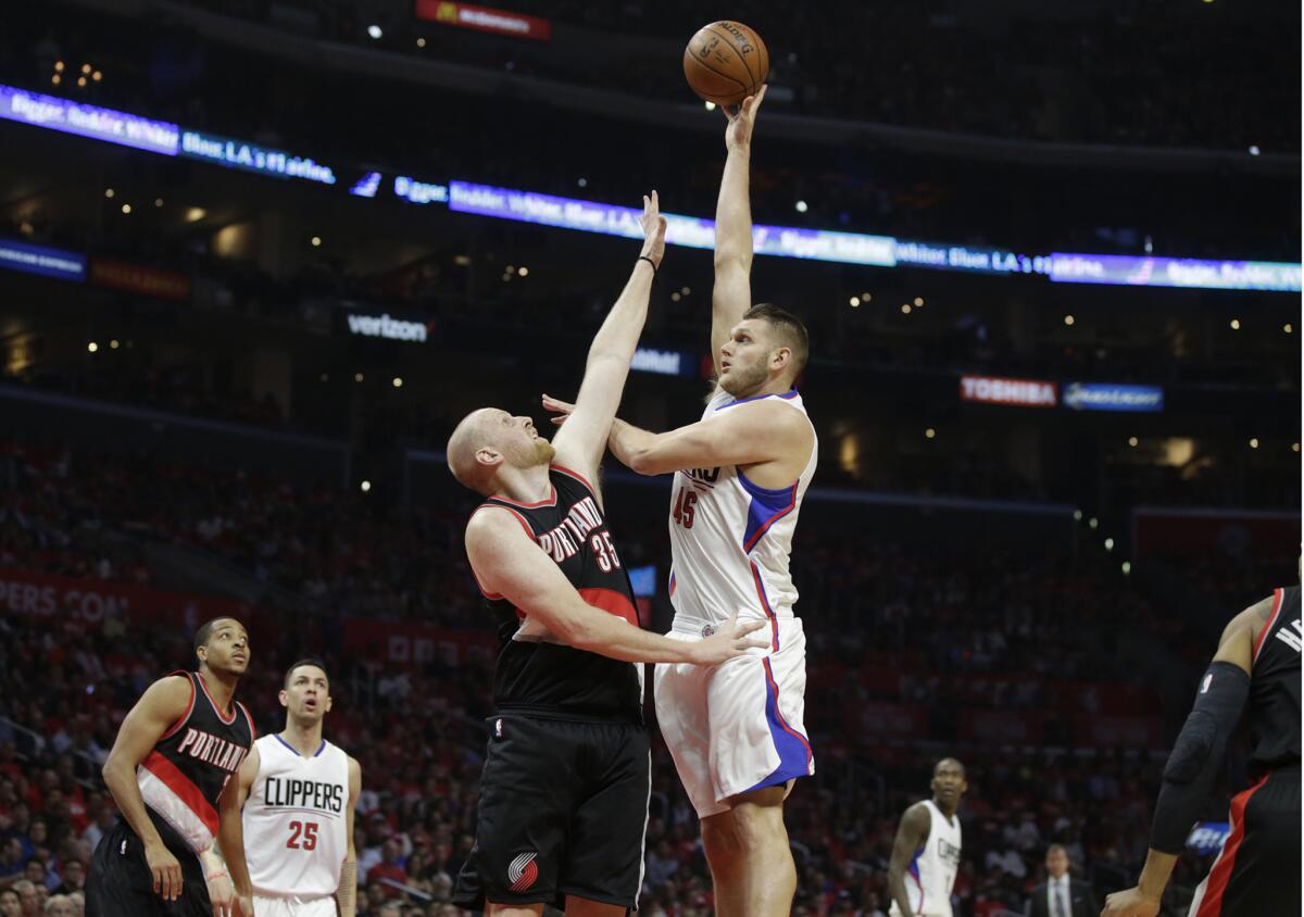 Clippers center Cole Aldrich shoots over Trail Blazers center Chris Kaman in the Clippers' 102-81 Game 2 victory.