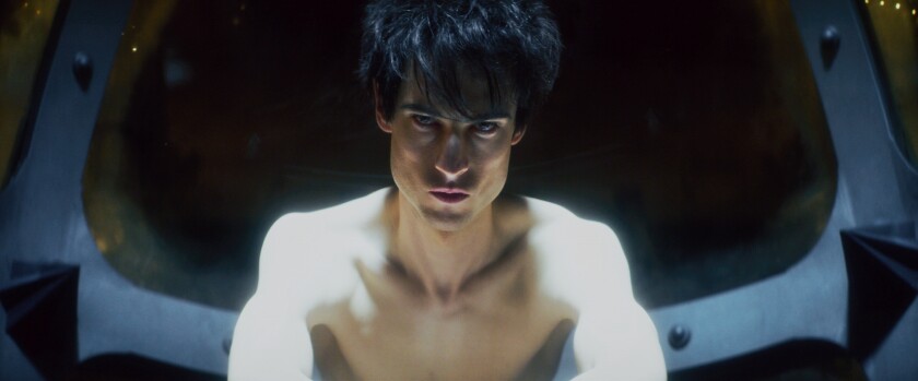 A pale, shirtless young man with chiseled cheekbones and dark hair