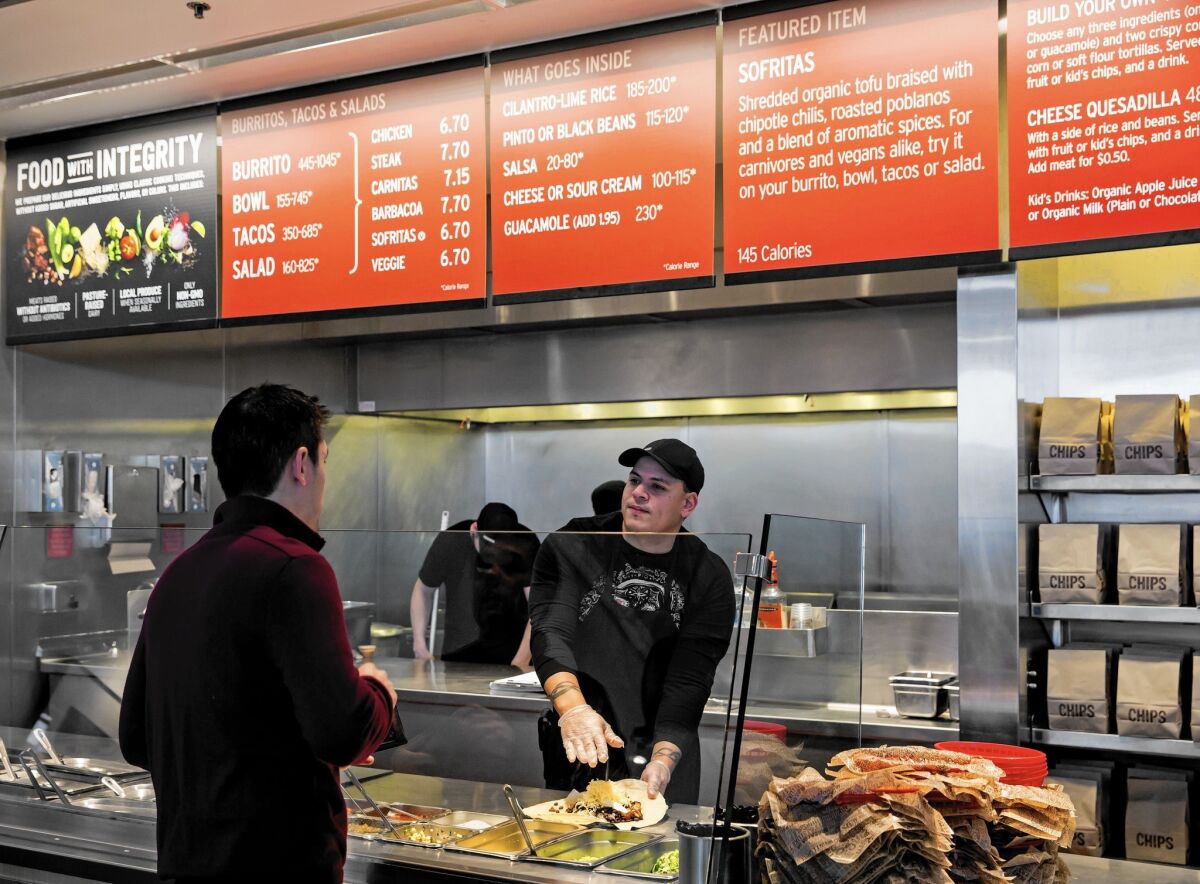 A Chipotle employee prepares a burrito for a customer in Seattle. Two E. coli outbreaks were tied to the chain in 2015.