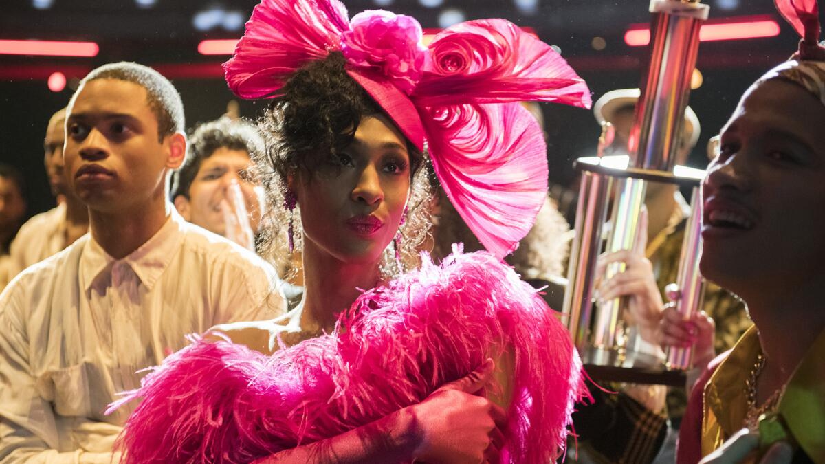 Mj Rodriguez wearing a hot pink hat and feather dress in "Pose"