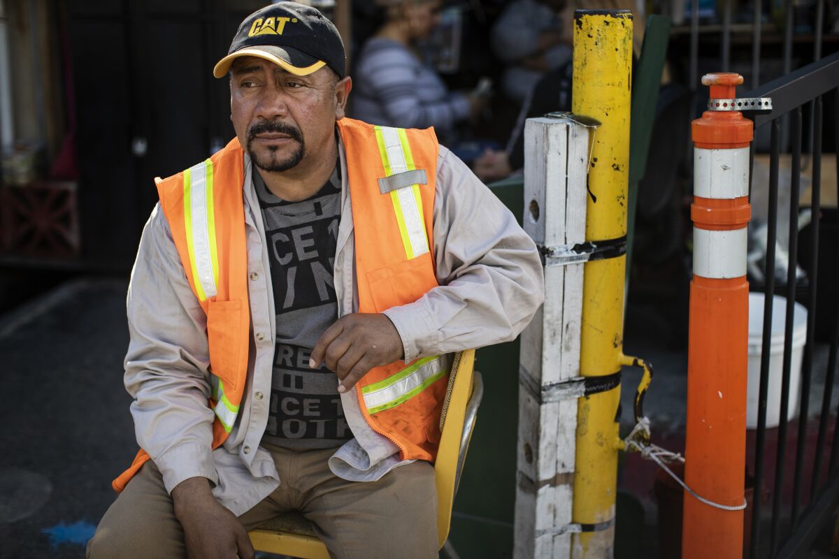 Jose Hernandez, jobs coordinator for the day laborers, waits in the Home Depot parking lot for work