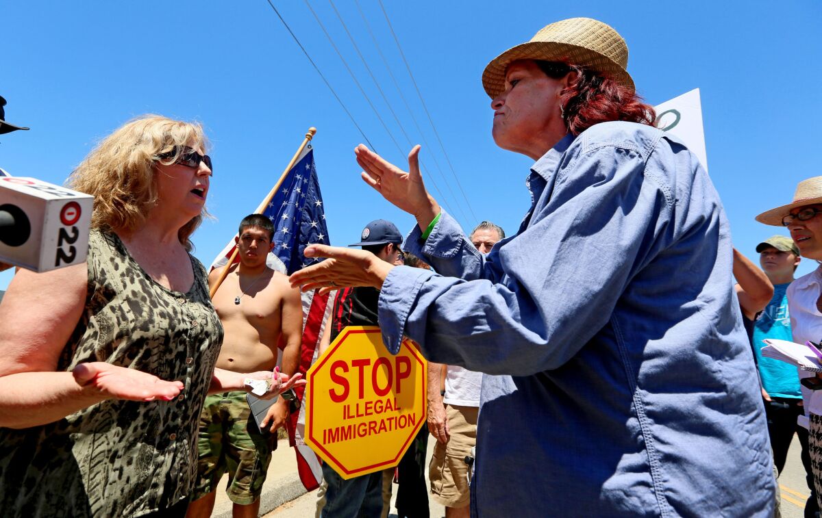 Anti-immigration activist Sabina Durden, right, and immigration supporter Mary Estrada, left, debate during a protest outside of the U.S. Border Patrol Murrieta Station on Monday.