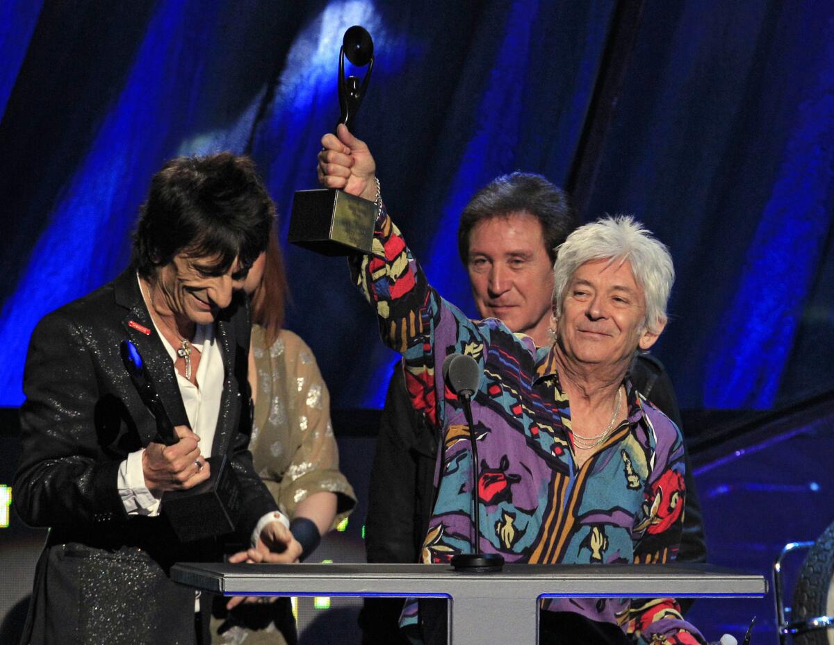 Ian McLagan, right, holds up his trophy in April 2012 after he and Ron Wood, left, and Kenney Jones, background, were inducted into the Rock and Roll Hall of Fame as members of the Small Faces/Faces, in Cleveland.
