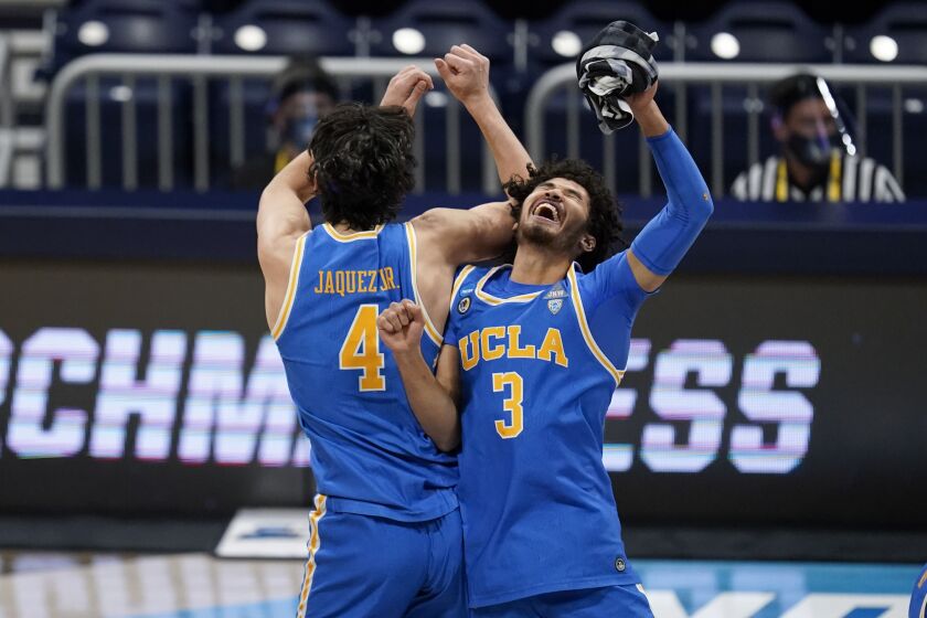UCLA guard Jaime Jaquez Jr. (4) and Johnny Juzang (3) celebrate after beating Alabama 88-78 in overtime of a Sweet 16 game in the NCAA men's college basketball tournament at Hinkle Fieldhouse in Indianapolis, Sunday, March 28, 2021. (AP Photo/Michael Conroy)