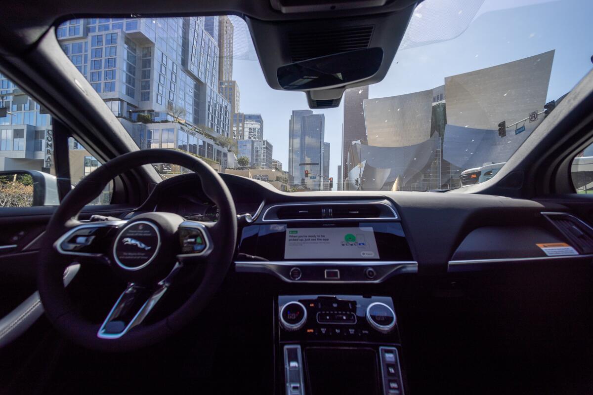 A Waymo robotaxi Jaguar I-PACEs driverless car drives around downtown Los 