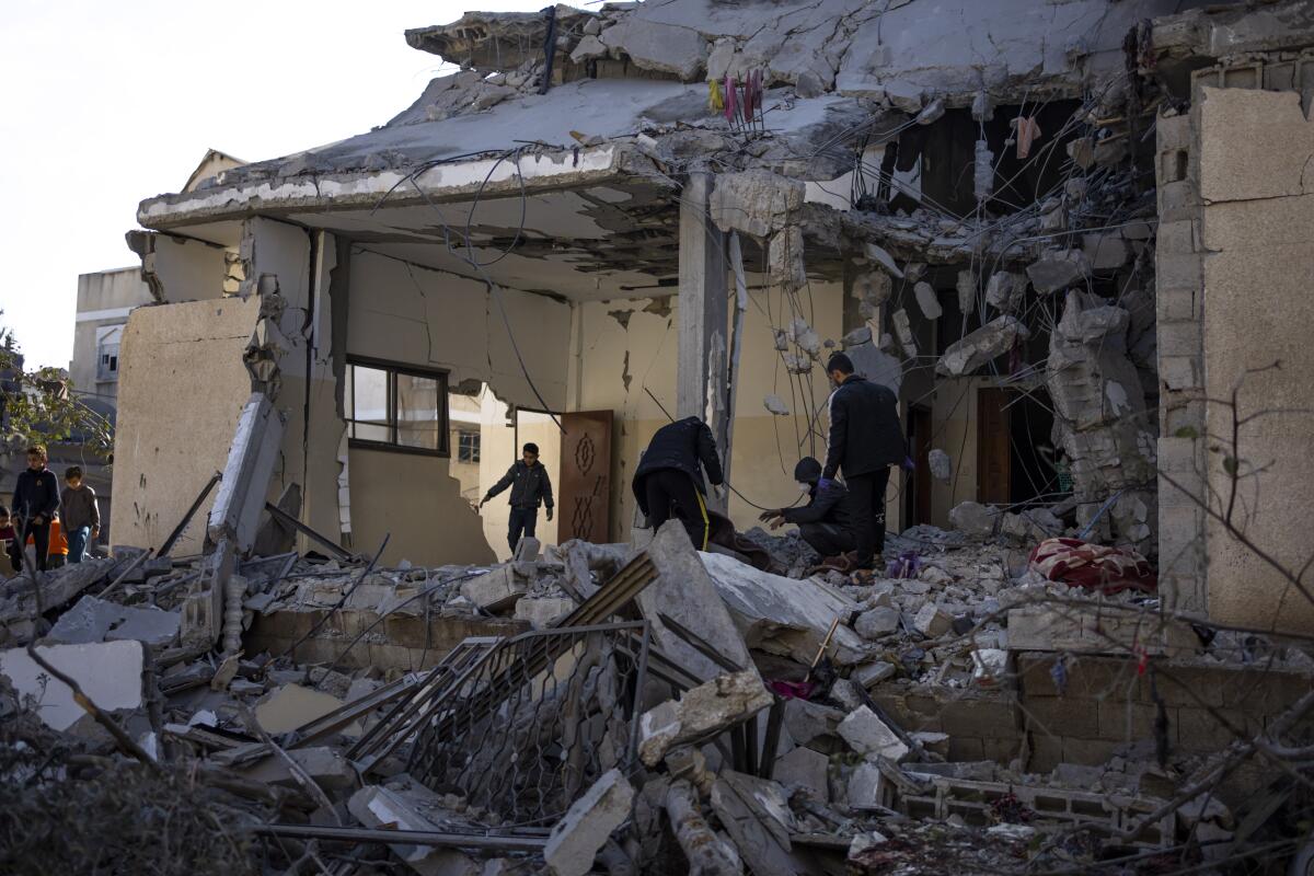 Palestinos revisan lo que quedó de una construcción tras un bombardeo israelí en Rafah, 