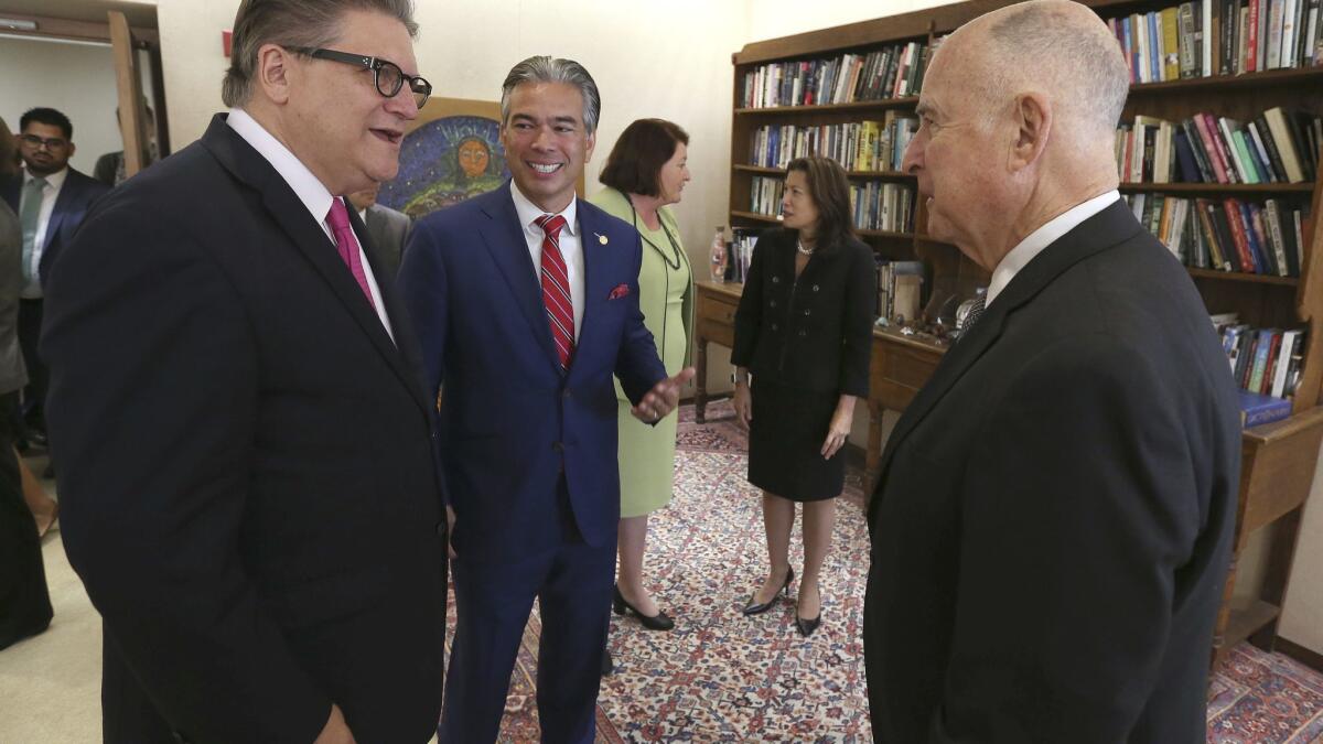 Gov. Jerry Brown, right, talks with state Sen. Bob Hertzberg, D-Van Nuys, left, and Assemblyman Rob Bonta, D-Alameda, before he signed their bill to end cash bail last month. (AP Photo/Rich Pedroncelli)