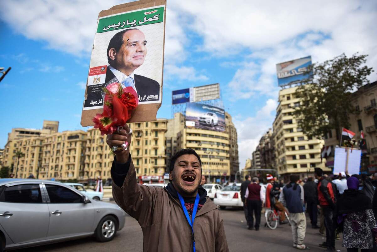 A pro-government Egyptian man holds up a portrait of President Abdel Fattah Sisi in Cairo's landmark Tahrir Square on Monday.