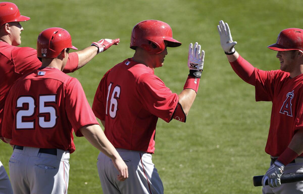 Angels catcher Hank Conger (16) celebrates his three-run home run with teammates Mike Trout, left, Peter Bourjos (25) and Kole Calhoun during an exhibition game against the Seattle Mariners last month.
