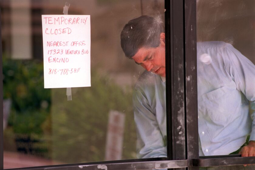 Western Financial Savings Bank employee Jerry Godfrey kept the bank doors locked Tuesday. Fingerprint Dust from the police investigation is still on the door from Mondays bankrobbery, murder. Mandatory Credit: Spencer Weiner/The LA Times