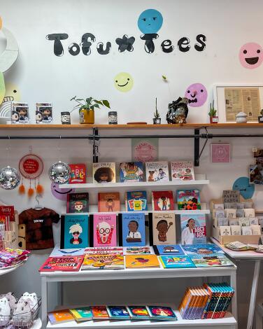 Colorful and cute merchandise on shelves under the words Tofu Tees