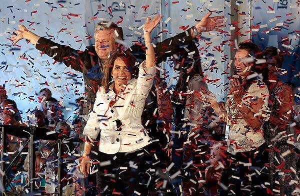 Rep. Michele Bachmann, with her husband, Marcus, waves to the crowd after placing first in the Ames straw poll.