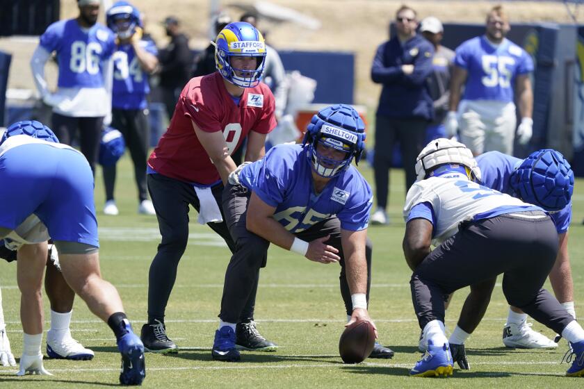 Los Angeles Rams quarterback Matthew Stafford takes a snap from center Coleman Shelton.