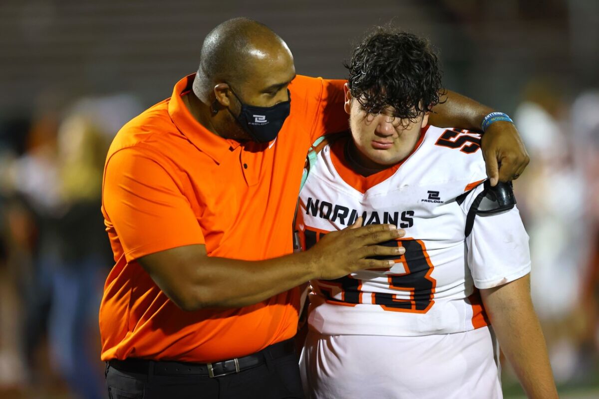 Beverly Hills coach Marquis Bowling consoles a freshman after a game.