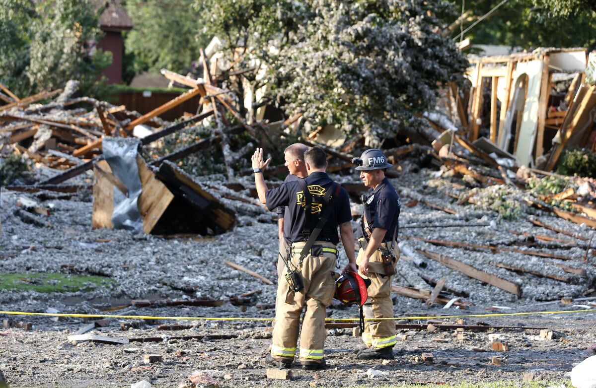 Plano Fire Department personnel work the scene after a home exploded at about 4:45 p.m. in the 4400 block of Cleveland Drive in Plano, Texas, Monday, July 19, 2021. (Stewart F. House/The Dallas Morning News via AP)