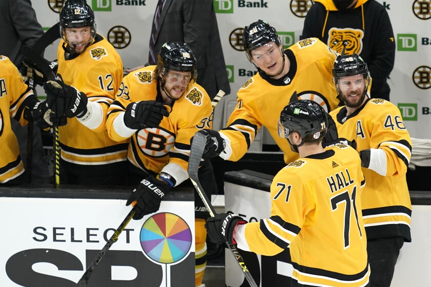 Boston Bruins left wing Taylor Hall (71) celebrates his goal with teammates on the bench in the third period of an NHL hockey game against the New York Islanders, Thursday, April 15, 2021, in Boston. (AP Photo/Elise Amendola)