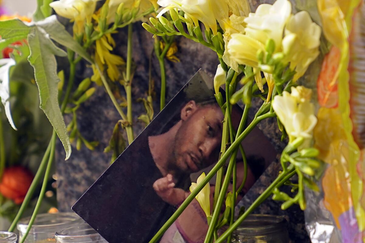 A photograph of shooting victim Sergio Harris sits among flowers at a memorial in Sacramento