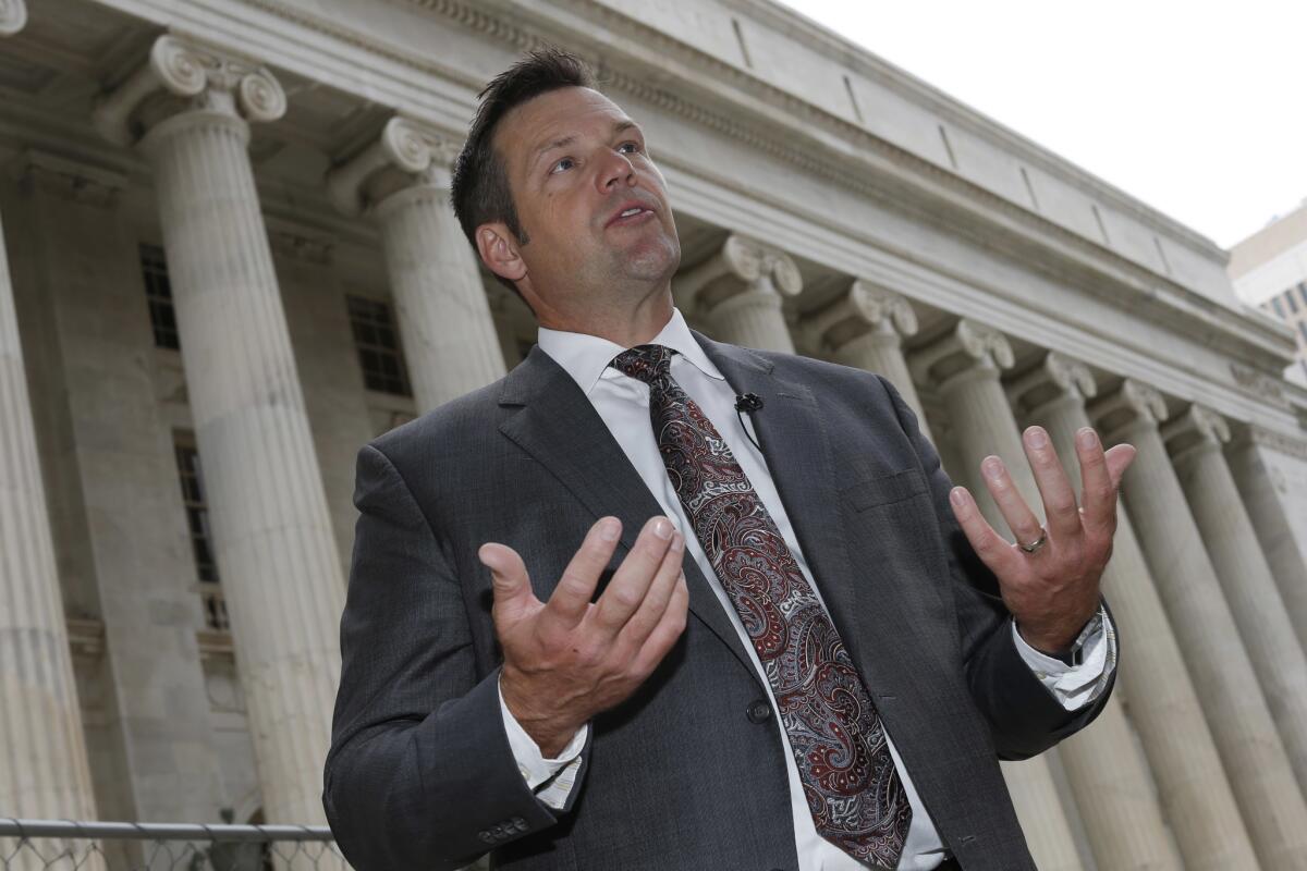 Kansas Secretary of State Kris Kobach responds to questions outside the 10th U.S. Circuit Court of Appeals in August.