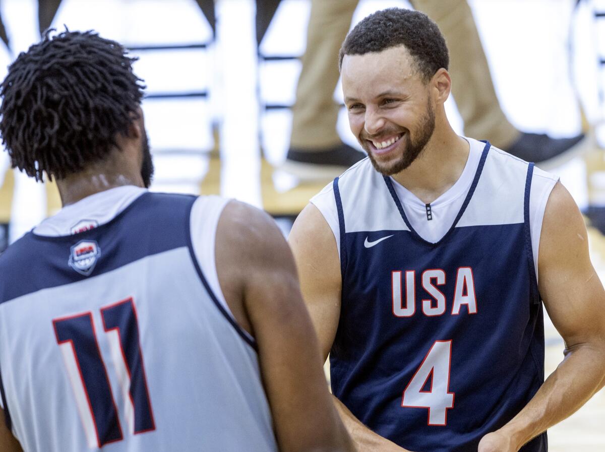 Stephen Curry, right, talks with Joel Embiid during training camp