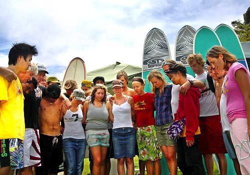 Members of Surfing the Nations pray before hitting the waves at Waikiki Beach in Honolulu.