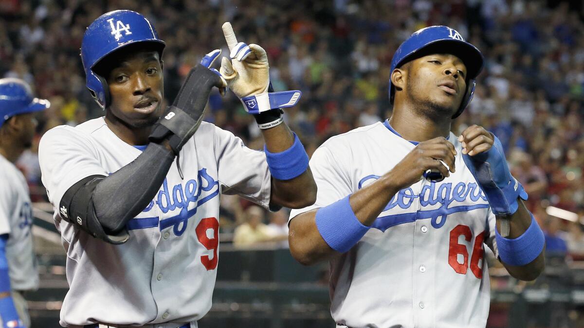 Dodgers teammates Dee Gordon, left, and Yasiel Puig celebrate after scoring runs in the third inning of a 3-1 win over the Arizona Diamondbacks on Wednesday.