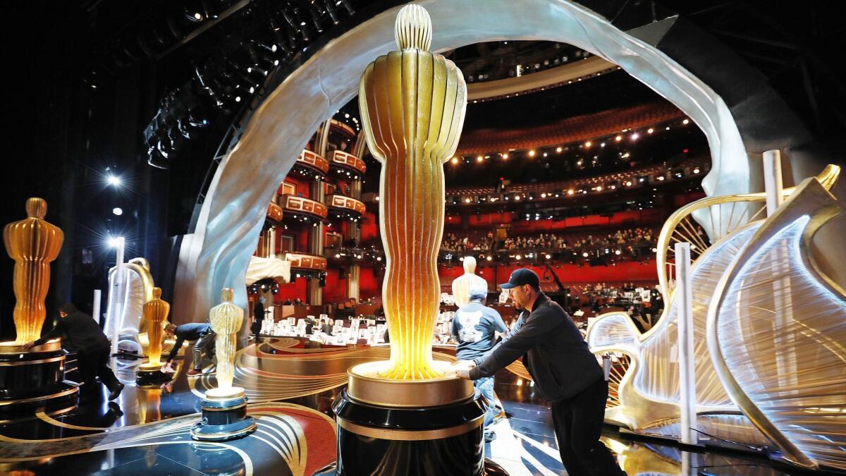 Christian Rosso with production rolls one of several Oscar statues into place onstage in the Dolby Theatre during rehearsals as preparations continue for the 91st Academy Awards.