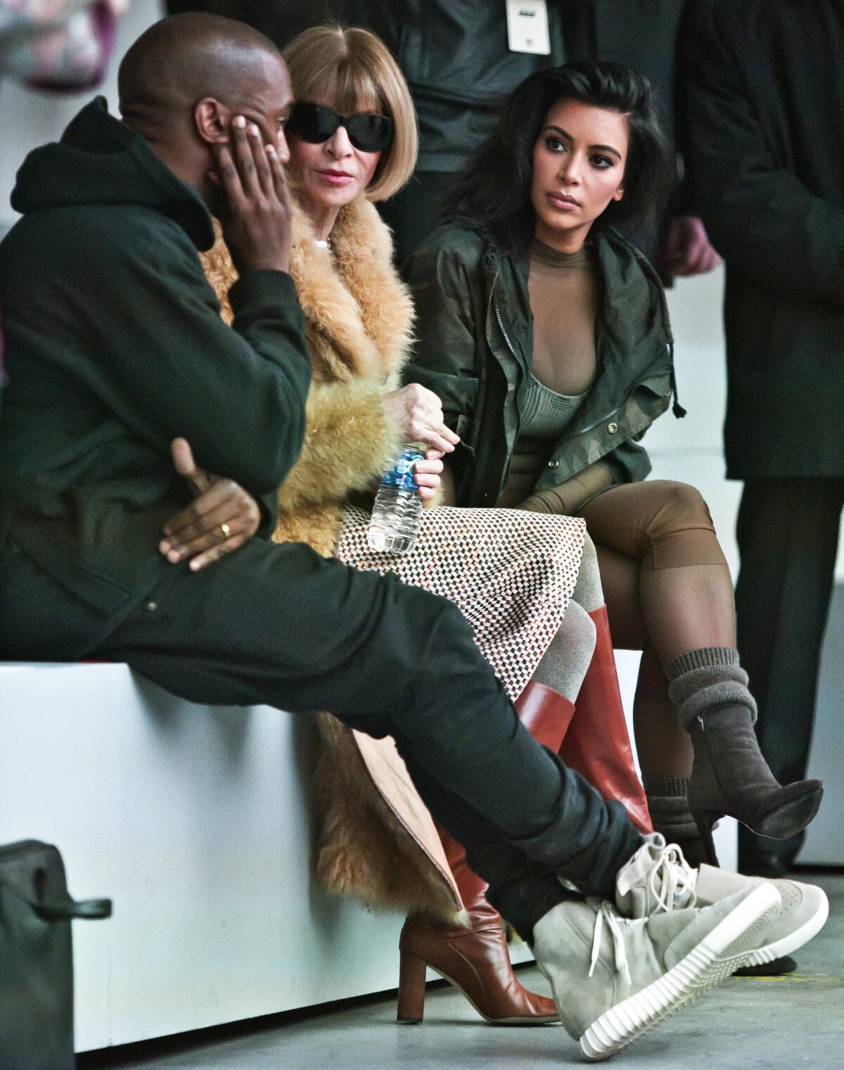 Showing off his Yeezy Boosts: Kanye West, from left, Vogue editor Anna Wintour, and Kim Kardashian before the showing of West's new shoe line during Fashion Week in New York. (AP Photo/Bebeto Matthews)