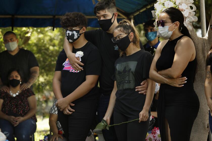 Jessica Aguirre, right, and her children, mourn her father, Fernando Aguirre who died of COVID-19 at the age of 69. 
