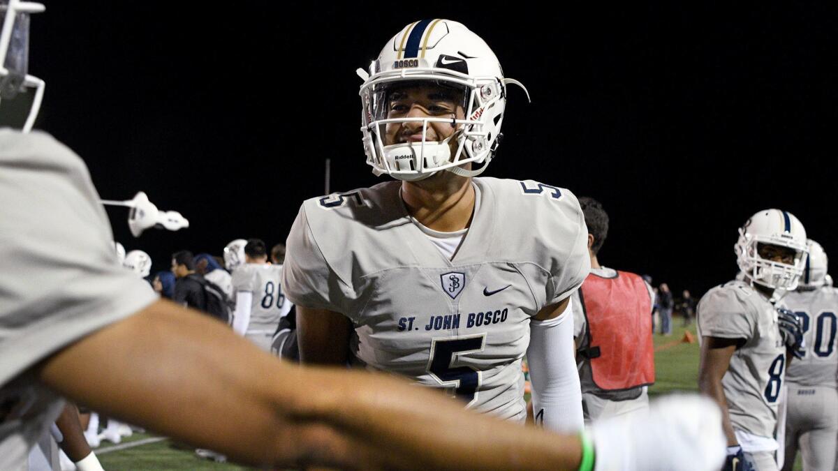 St. John Bosco quarterback D.J. Uiagalelei celebrates with teammates on the sidelines after passing for a touchdown against Oaks Christian in November.