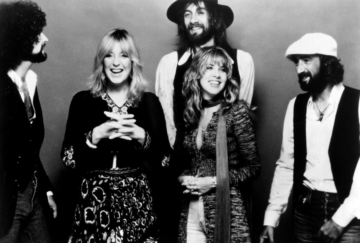 A five-piece rock band, composed of three men and two women, poses for a portrait in the late 1970s.