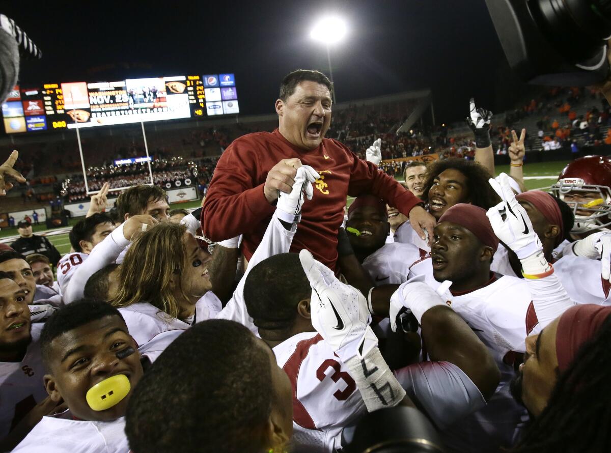 USC interim football coach Ed Orgeron celebrates with his team after a win over Oregon State