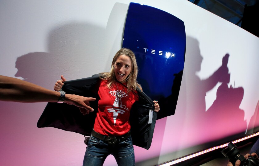 Carrie Lederer, a Santa Monica resident and Tesla car owner, poses with the Powerwall during an event at the company's plant in Hawthorne on Thursday.