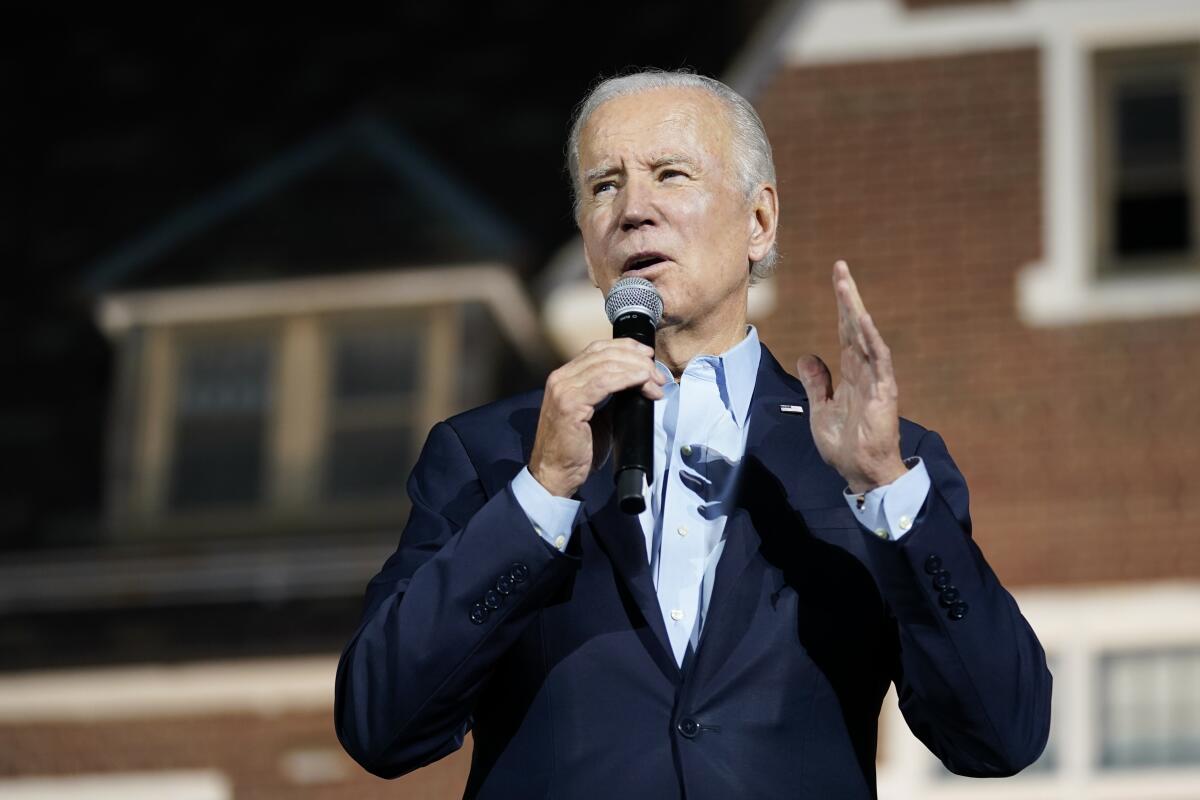 President Joe Biden speaks into a microphone