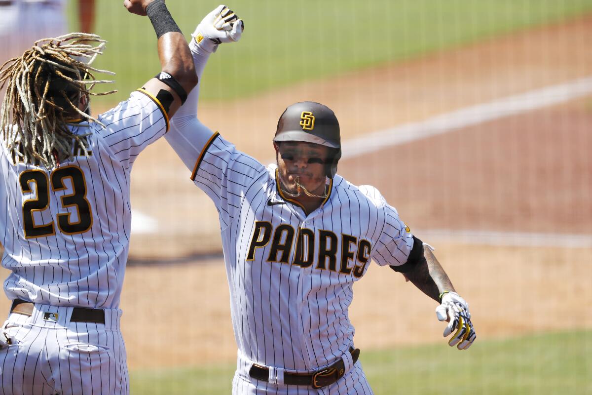 Manny Machado of the San Diego Padres celebrates a home run with Fernando Tatis Jr.
