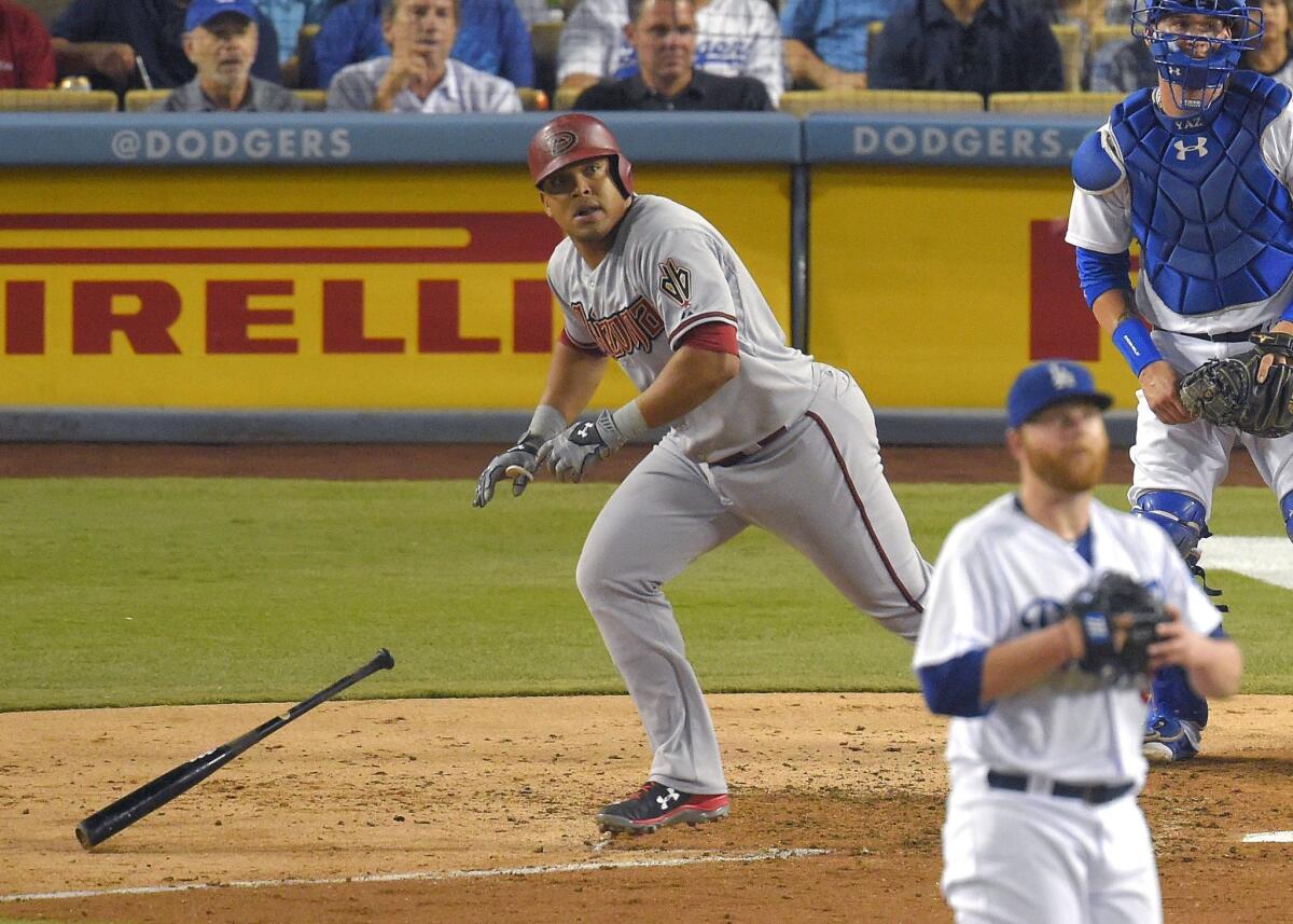 Arizona's Yasmany Tomas, left, hits a solo home run as Dodgers pitcher Brett Anderson and catcher Yasmani Grandal watch on Monday night.