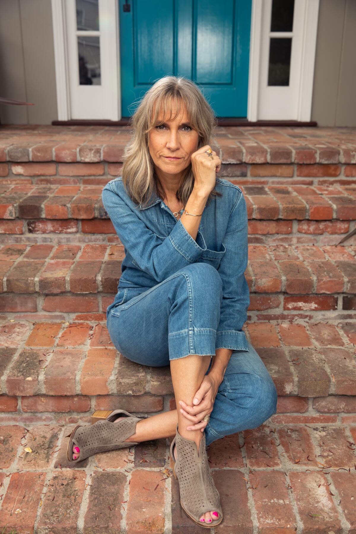 Writer Dana Stevens sits on brick steps for a portrait.