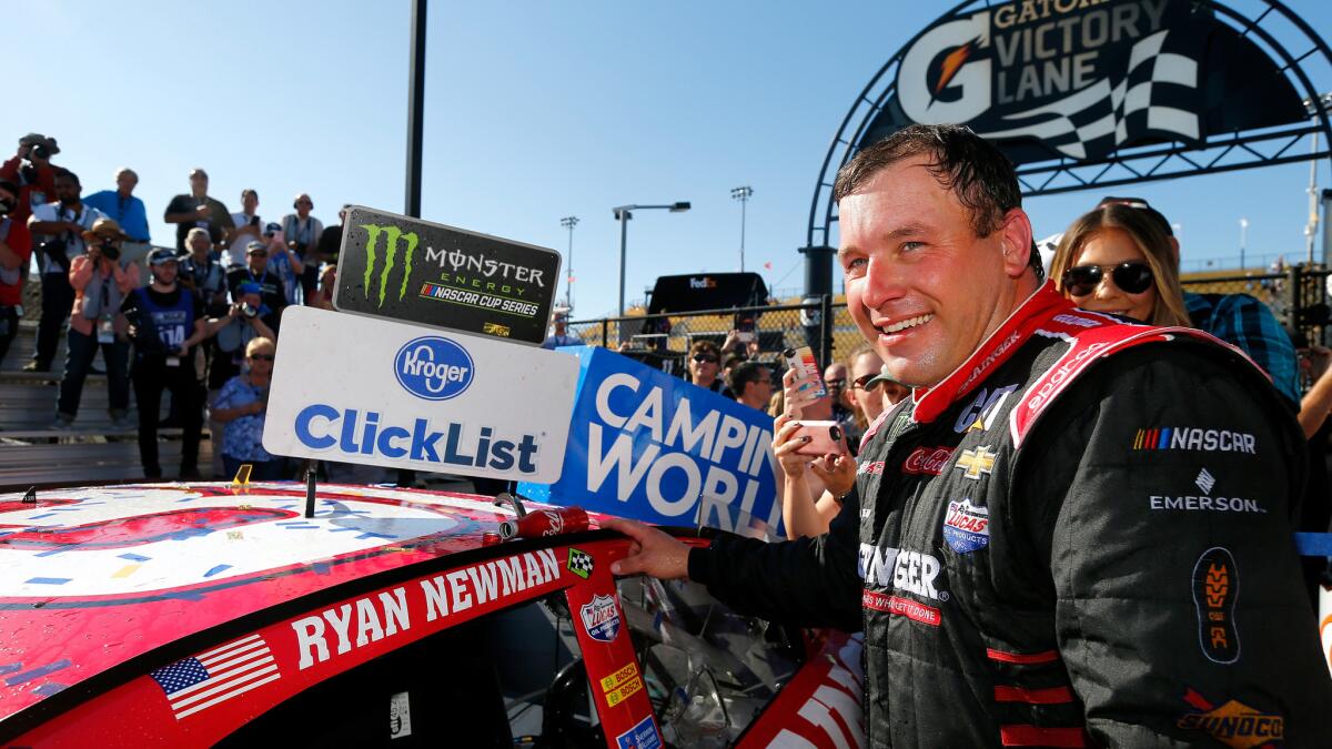 NASCAR driver Ryan Newman applies the Monster Energy NASCAR Cup winner's sticker to his car in Victory Lane on Sunday at Phoenix International Raceway.