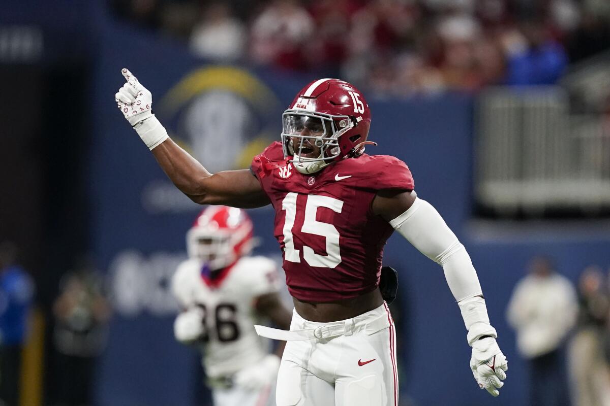 Alabama linebacker Dallas Turner holds up an arm and pointer finger and celebrates after making a stop. 