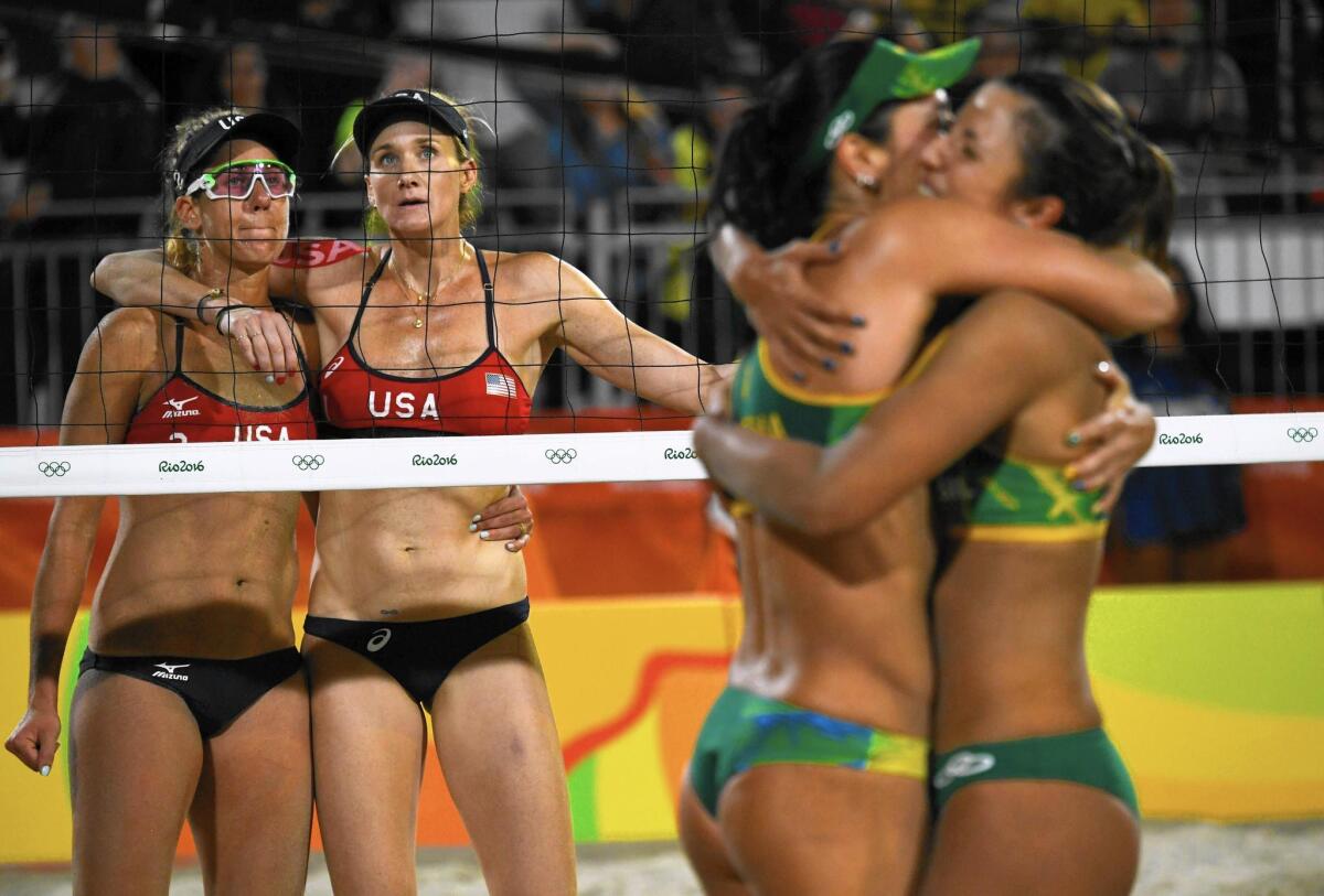 April Ross, left, and her teammate Kerri Walsh Jennings react as Brazil’s Agatha Bednarczuk and Barbara Seixas De Freitas, far right, celebrate after winning the women’s beach volleyball semifinal match between USA and Brazil in Rio de Janeiro on Tuesday.