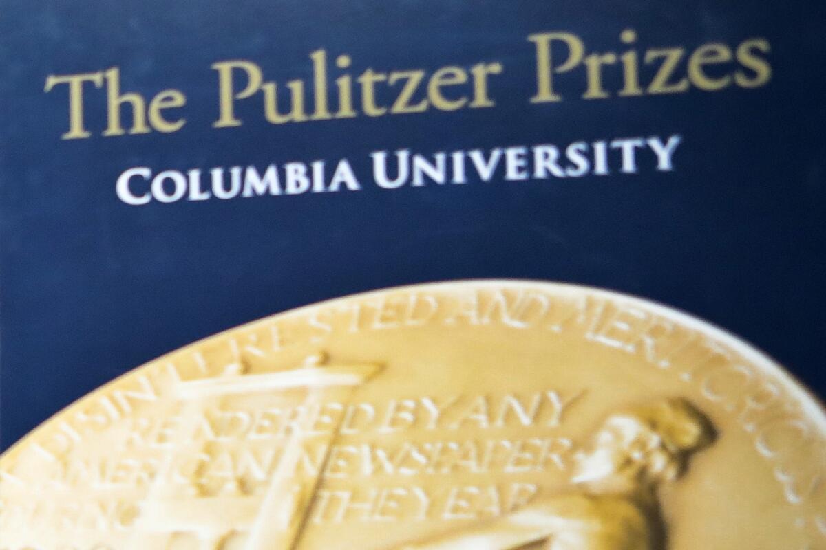 A golden Pulitzer Prize emblem with the words "The Pulitzer Prizes Columbia University" written above it