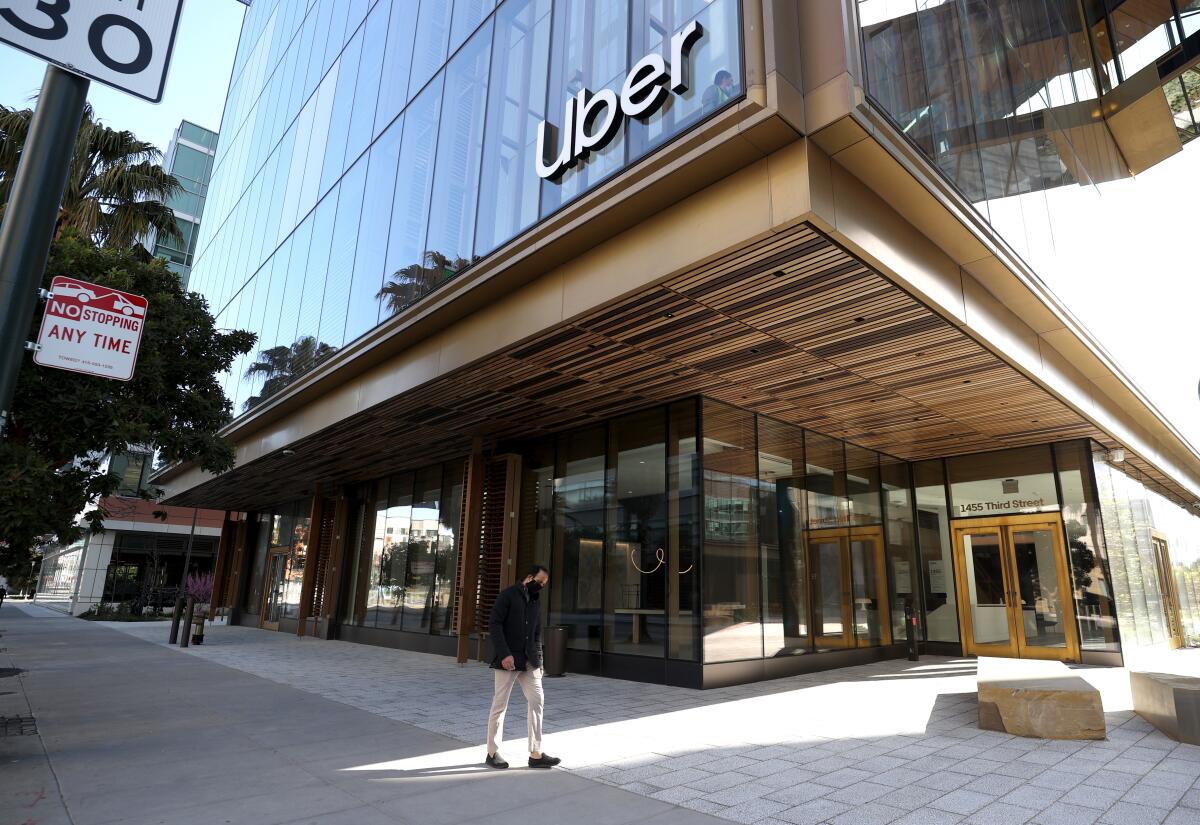 A pedestrian walks by the Uber headquarters in San Francisco. 