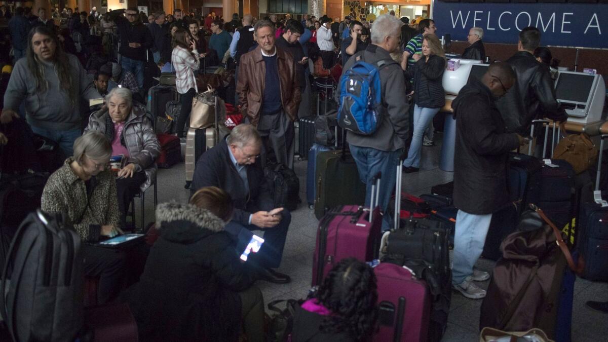 Passengers wait in a dark terminal at Hartsfield-Jackson International Airport on Sunday.