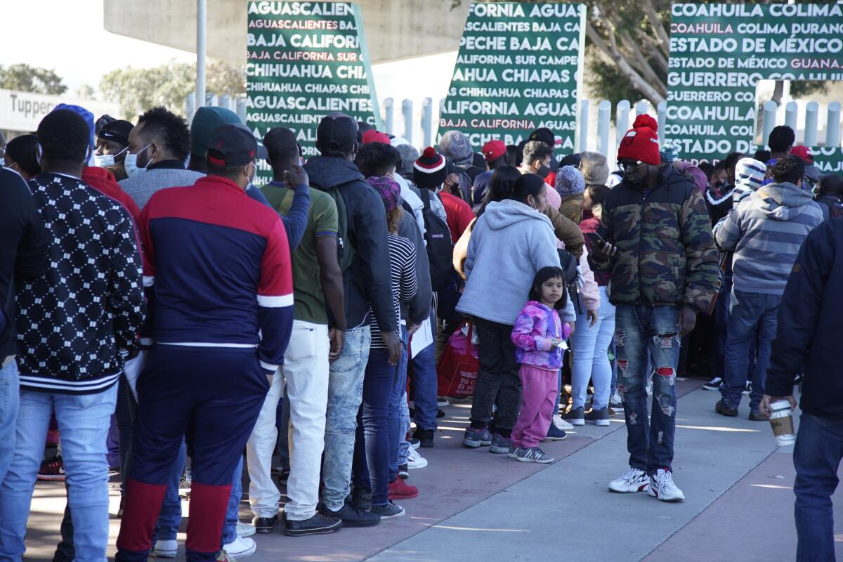 People stand in line at a border crossing