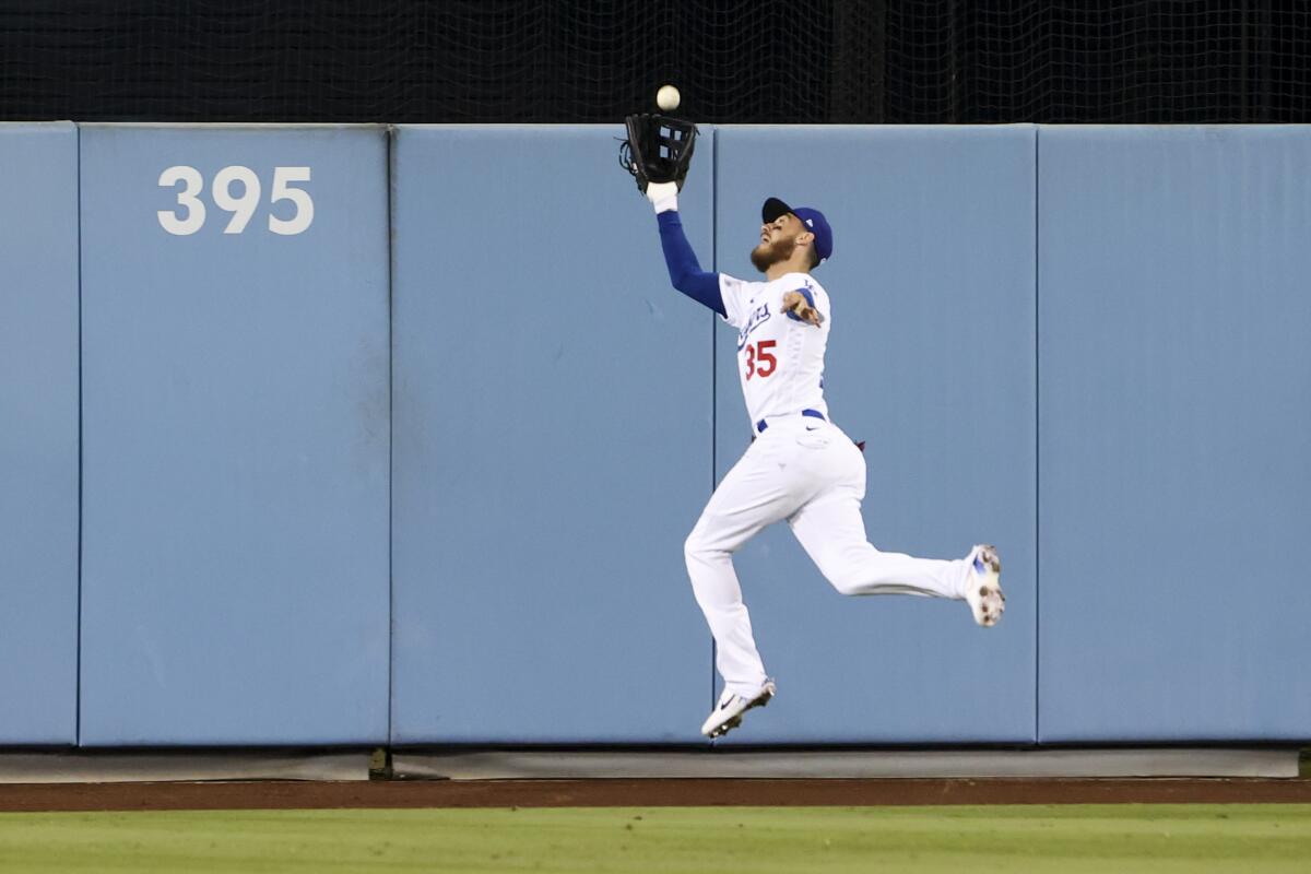 Dodgers center fielder Cody Bellinger catches a fly ball hit by San Diego Padres' Austin Nola.