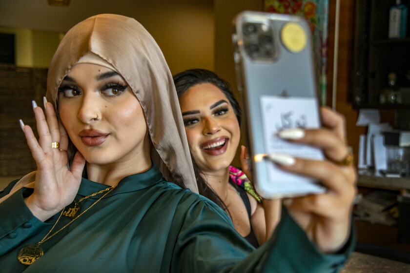 Rahan Alemi poses for a selfie as her sister Ombahran watches.