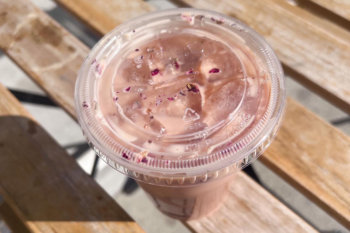A Dirty Rose Girl (rose latte) in a clear plastic cup with a lid