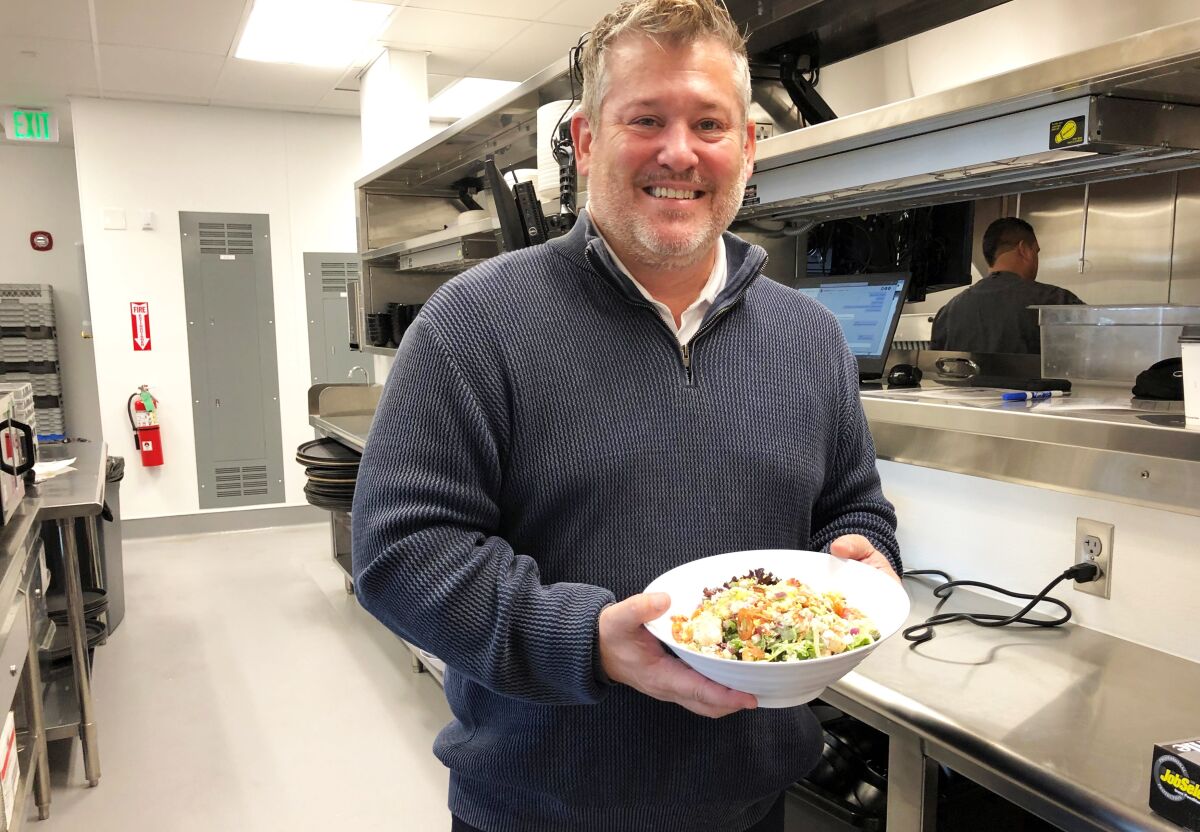 Adam Flierl, vice president of food and beverage for Cinépolis Luxury Cinemas, holds a made-from-scratch Cobb salad at the chain's soon-to-open La Costa Town Square location on Wednesday.