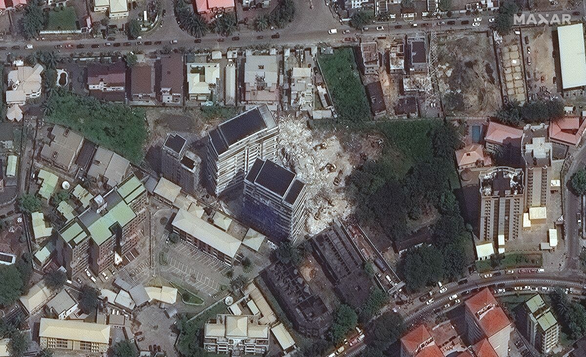This satellite image provided by Maxar Technologies shows the close up of a collapsed building, center, in Lagos, Nigeria on Wednesday, Nov. 3, 2021. The 21-story luxury apartment building under construction toppled Monday and it took several hours for officials to launch the rescue effort. Authorities have arrested the property's owner, according to media reports, saying that his building permit only allowed for a 15-story structure. (Satellite image ©2021 Maxar Technologies via AP)